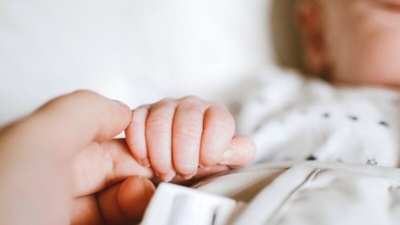 baby holding mother's finger
