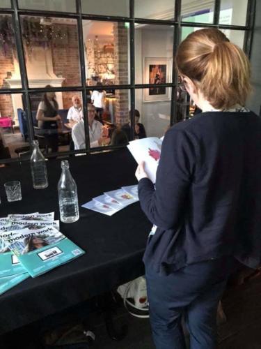 An attendee peruses "Cora's Dragons" by Claire 'Fairy' Colston.